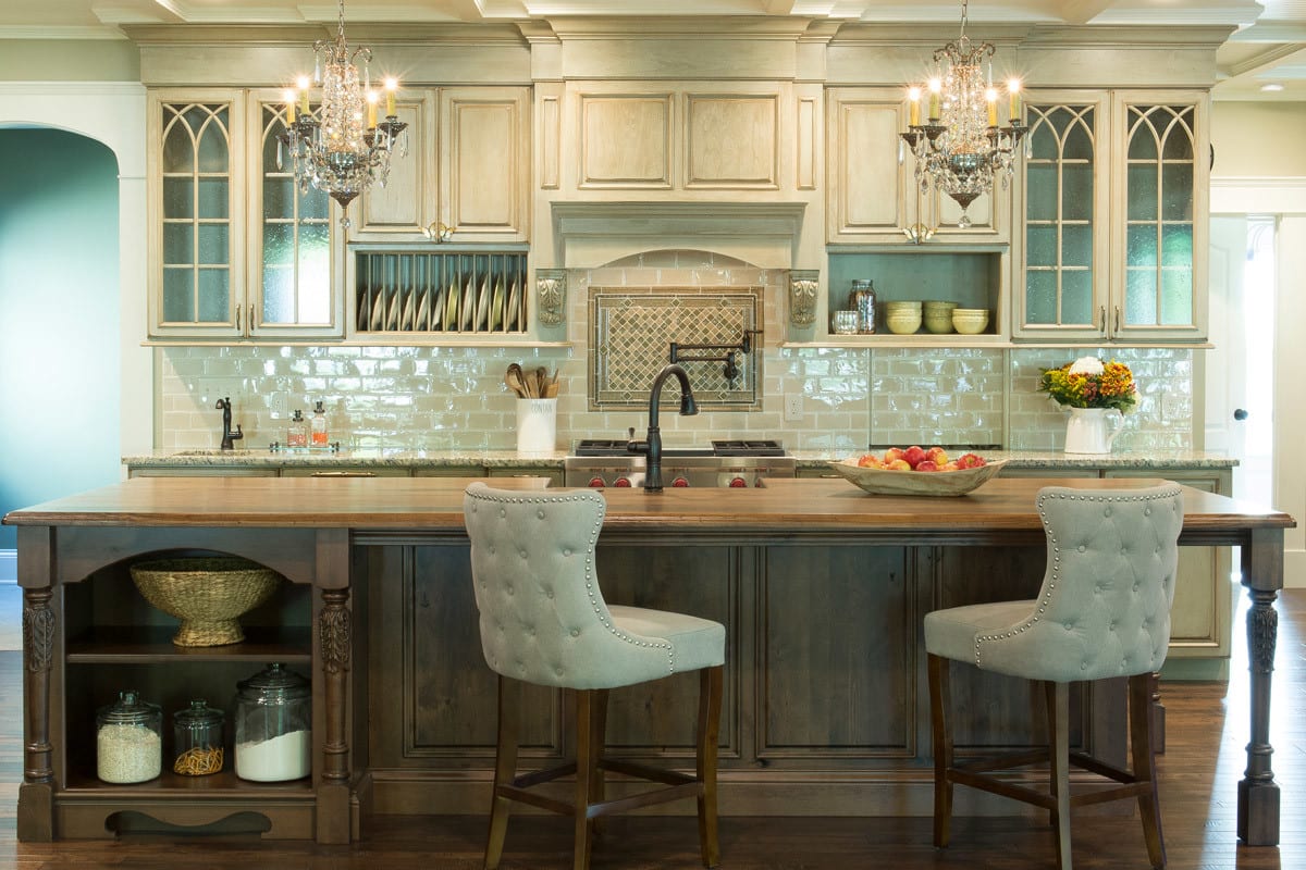 a spacious kitchen with a large island and cream wooden cabinetry