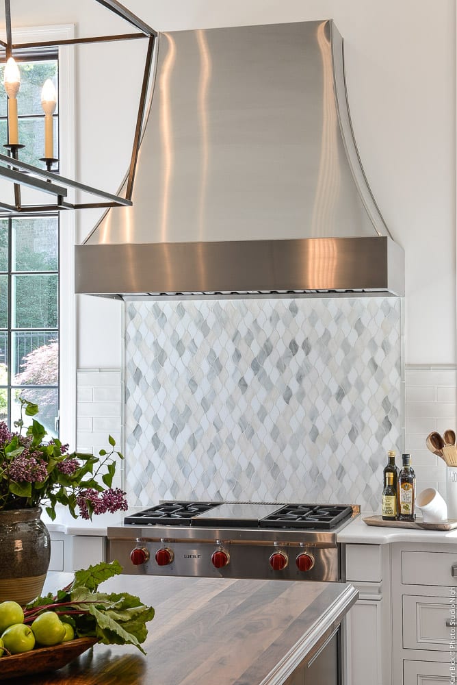 metal chimney hood with glass mosaic backsplash in kitchen remodel