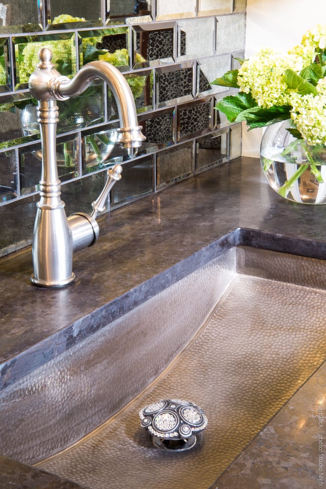 metal trough sink with mirror tile backsplash