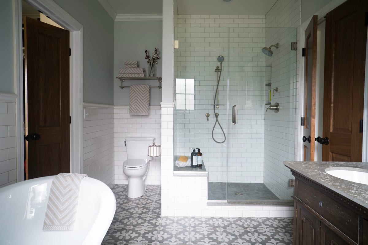 subway tile with frameless glass shower door and gray tile
