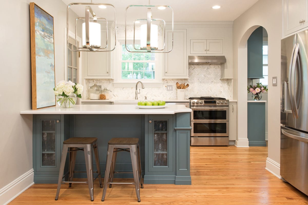 small kitchen remodel with blue and white cabinetry and silver fixtures