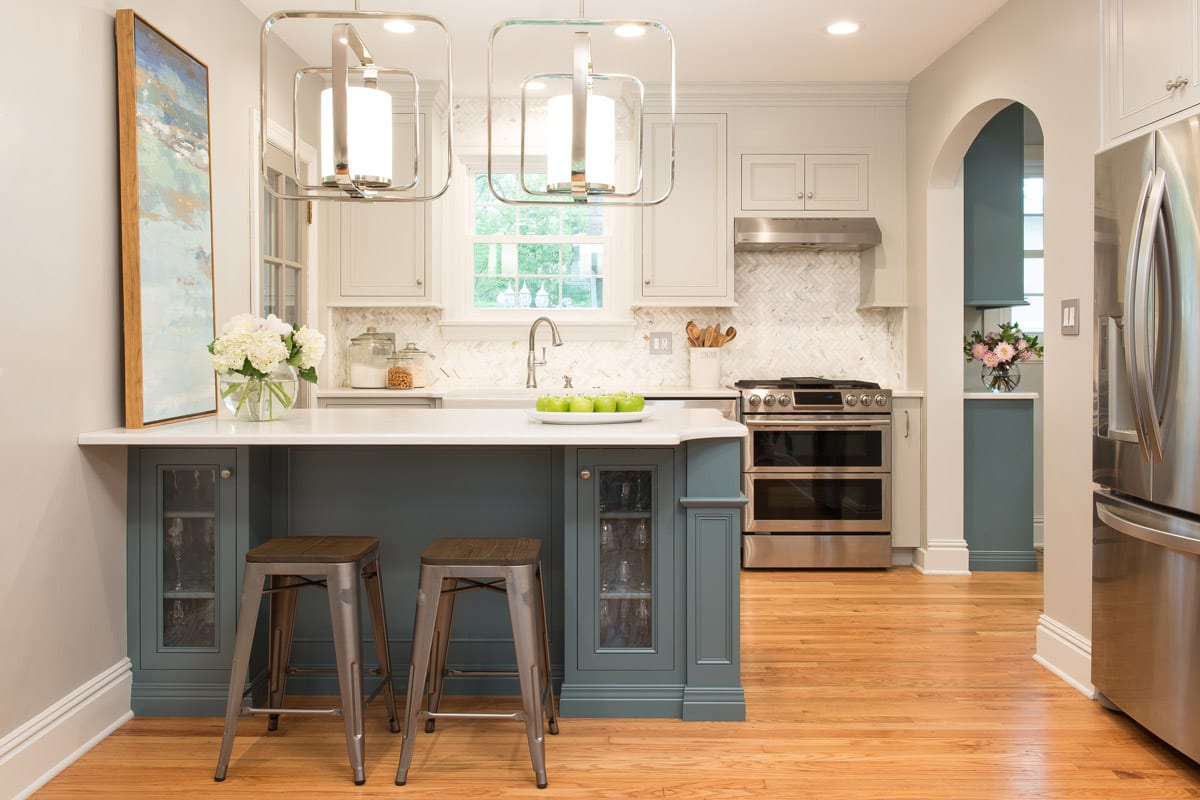 small kitchen remodel with blue and white cabinetry and silver fixtures