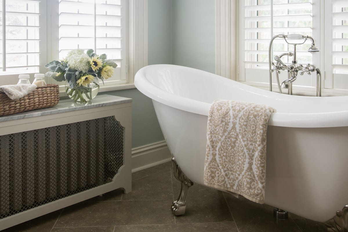 airy bathroom with a large white freestanding bathtub