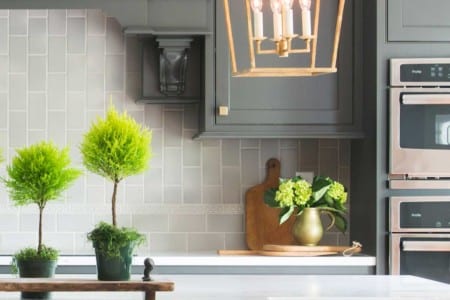 close up in an elegant kitchen with charcoal colored cabinets and light aluminum tile backsplash