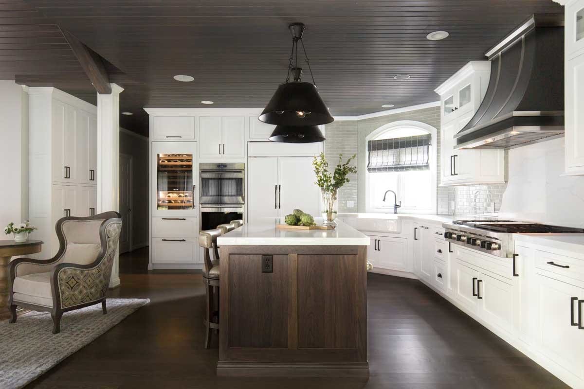 The soft, warm hues coming from the wood texture in this kitchen find balance with sleek black and white lines. This is a true chef’s kitchen, equipped with top-of-the-line Sub Zero Wolf appliances and ample spice storage. Matte black iron and metal finishes along with grey glass subway tiles top off the look with a refined, equestrian finish.