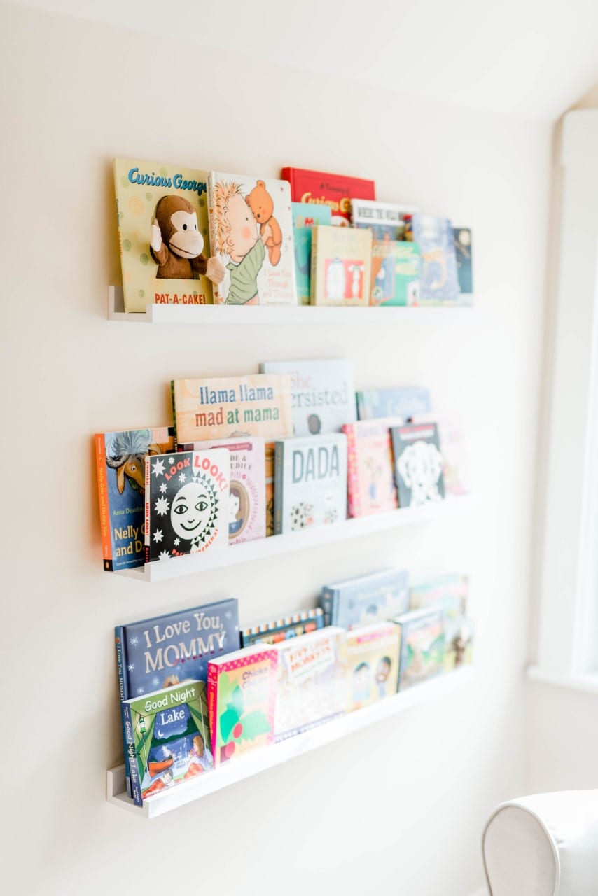 Floating bookshelves filled with children's books, perfect for a kid's, toddler's, or newborn's room.