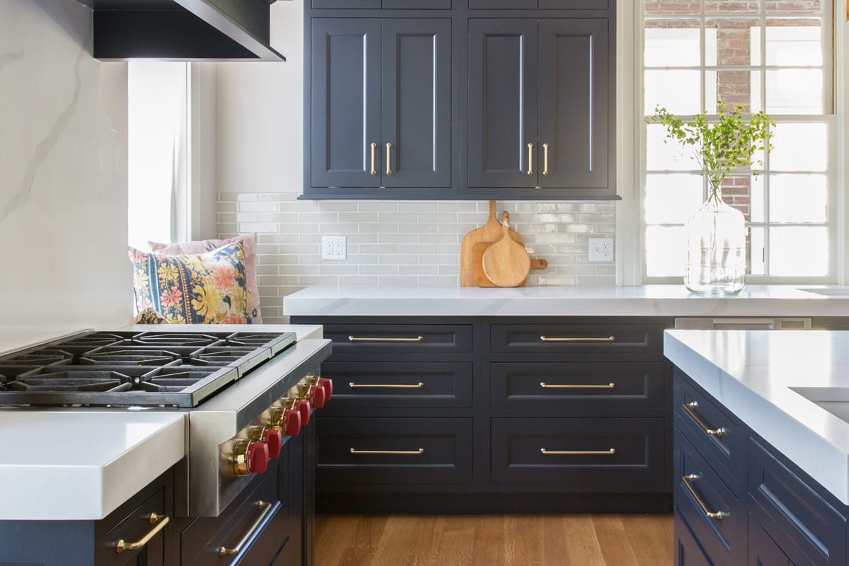 For this local family, the kitchen is their cornerstone. After a long day, everyone gathers to create and enjoy a meal together. The light fixture, hardware and faucet make the room feel polished and delicate. Classic marble countertops add a sense of elegance and pairs perfectly with brass accents. Deep navy cabinetry contrasts against the crisp white in the marble, while bringing a calming effect. The range hood, featuring a refined pattern, is made of printed marble. Each evening, the family’s twin girls sit here to watch their mom cook dinner.