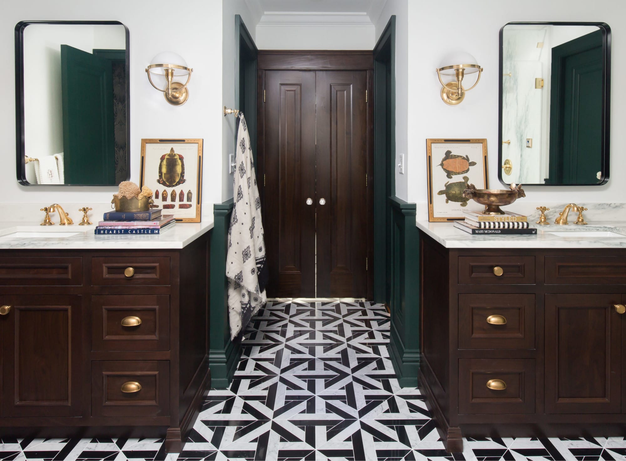 This remodel took a bold turn leaving patterned blue wallpaper and beige tile behind. It has no shyness as it sports a geometric tile floor, deep green wainscot panelling, and marbled shower walls. The patterned wallpaper brings warmth and energy to the space every day.