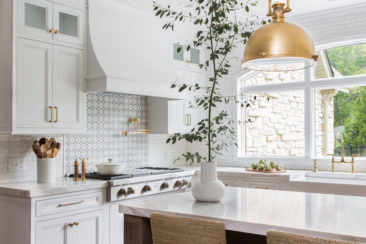 gorgeous bright white kitchen with gold fixtures and natural light