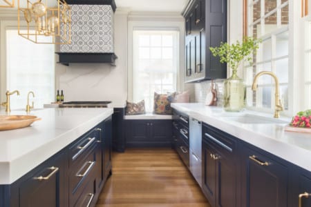 Home kitchen renovation wood floors, black and white appliances, with gold accents and grey wall patterns.
