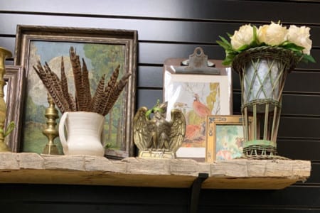 a rustic wooden mantel with vintage and brass decor