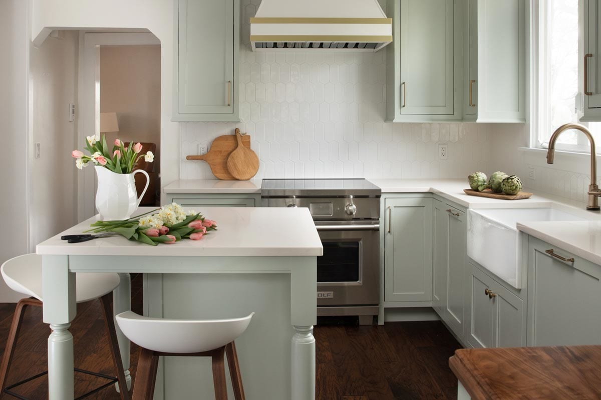 Beautiful airy sage green and white kitchen with wood accents