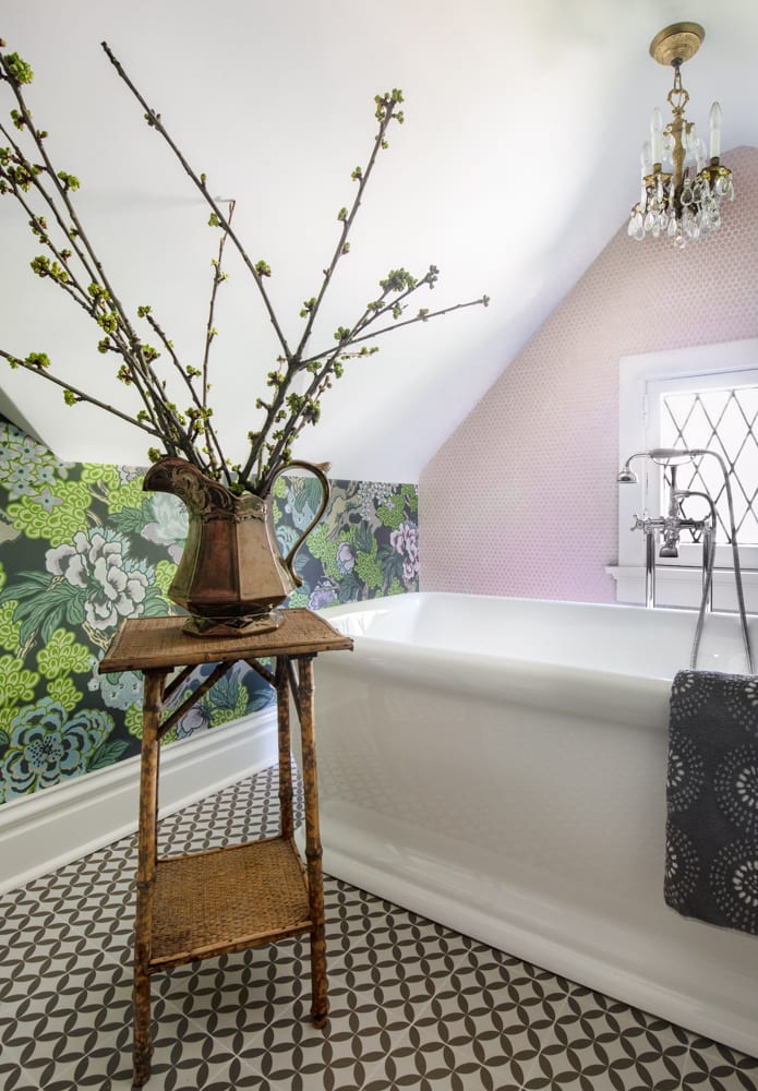 Luxurious bathroom with succulent wallpaper, triangular ceiling and pink cabinets