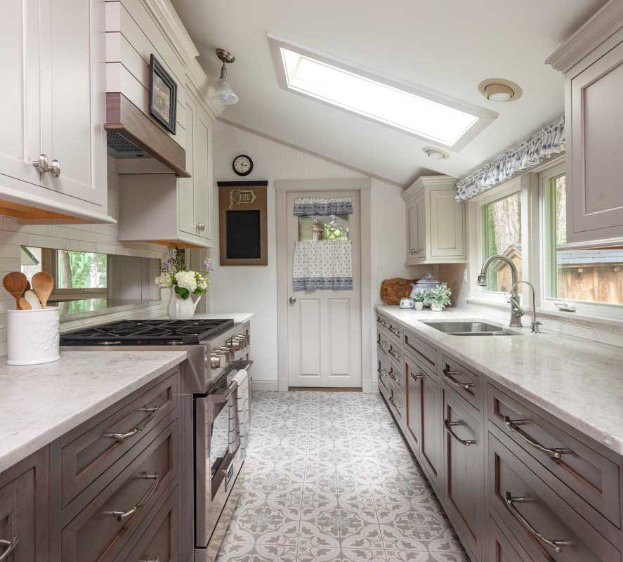a cottage style kitchen with patterned tile and neutral accents