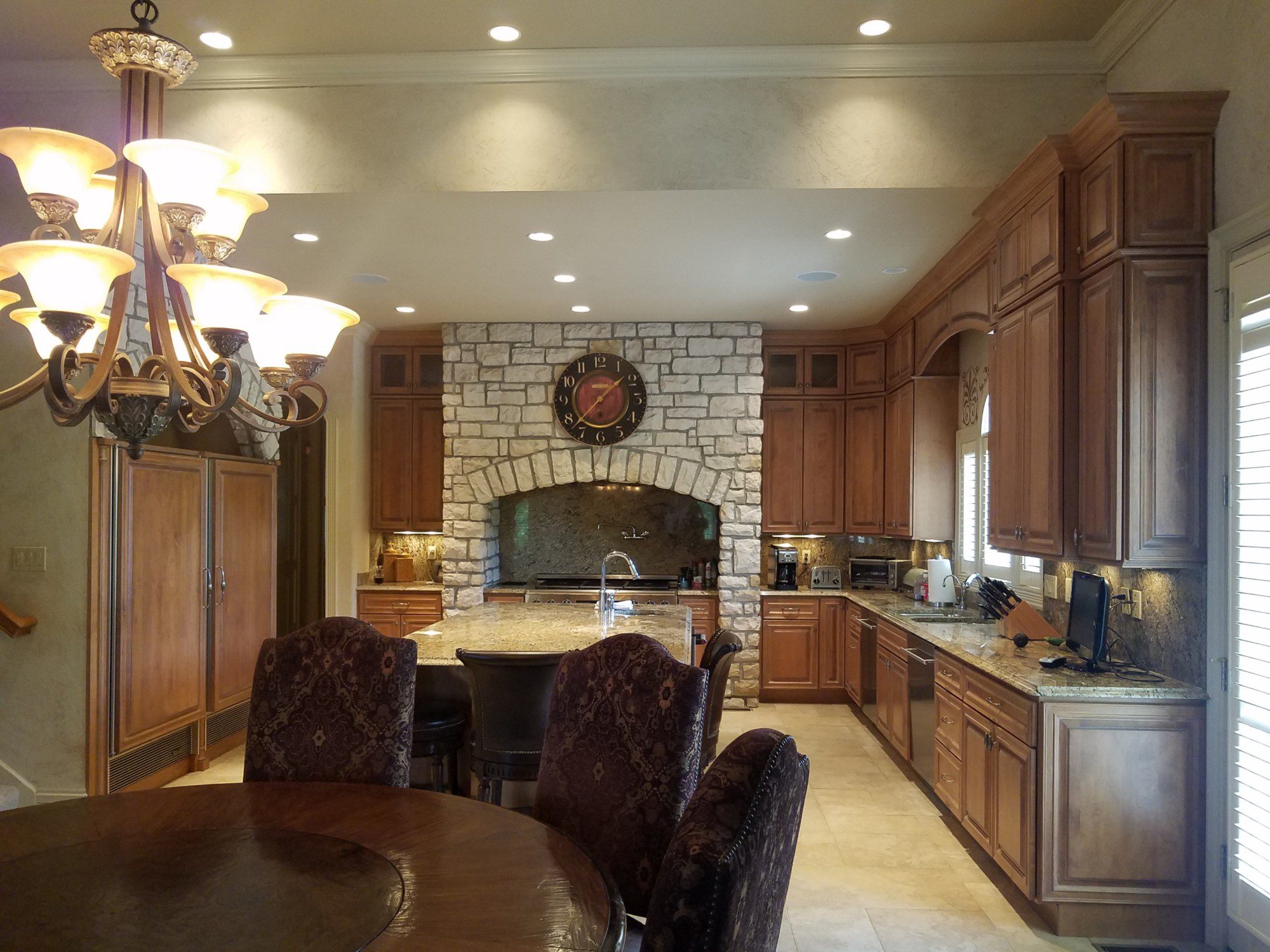 dark tuscan kitchen with brown cabinetry and stone archways