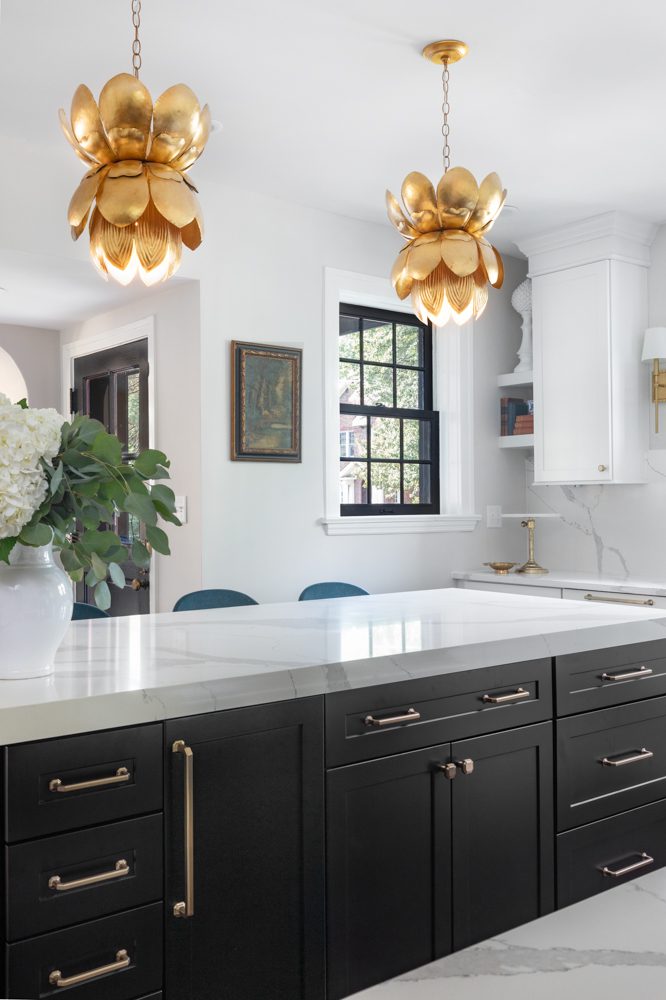 large kitchen island with black cabinetry and gold hardware