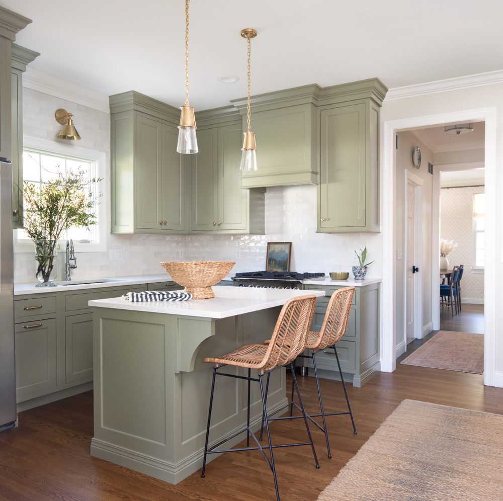 bright kitchen with sage green cabinetry and white countertops