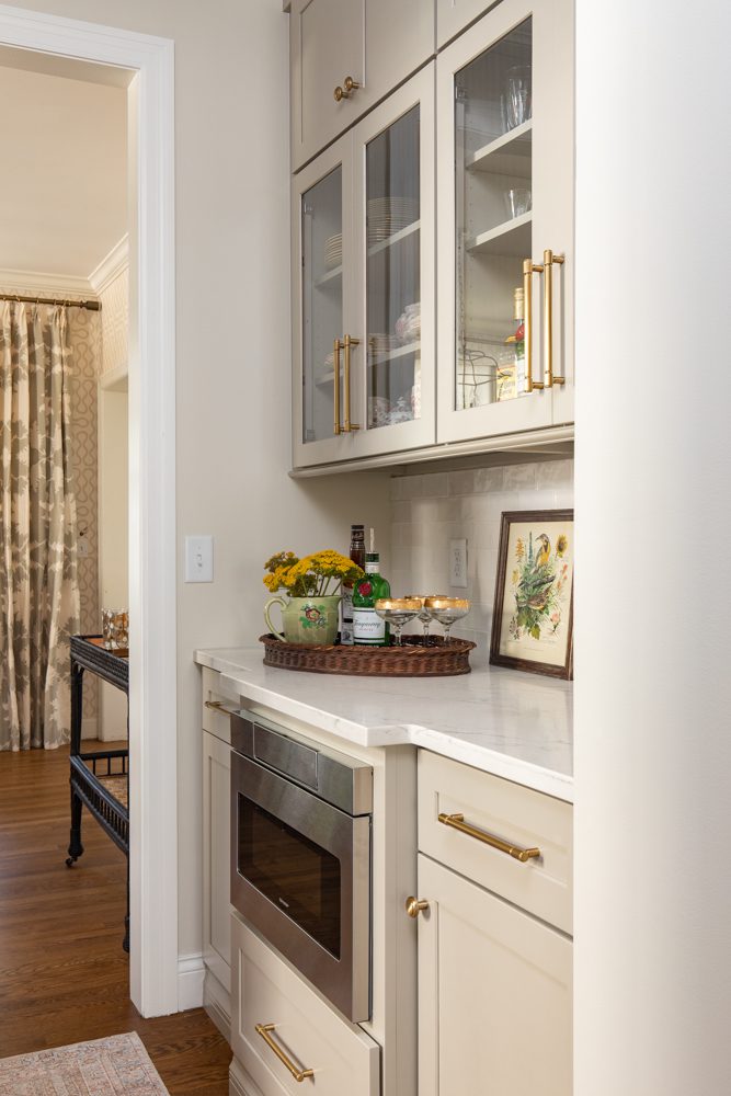 small nook with beige and glass cabinetry and a built in microwave