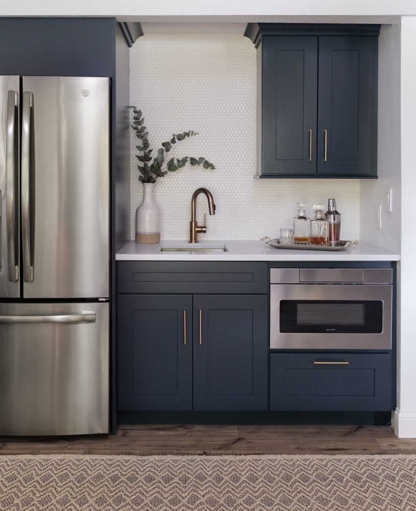 small kitchen with navy blue cabinetry and gold hardware