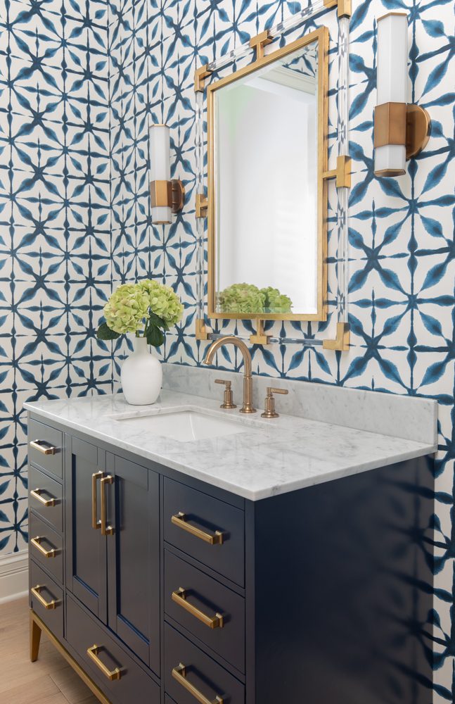 gorgeous bathroom with blue and white wallpaper and gold accents
