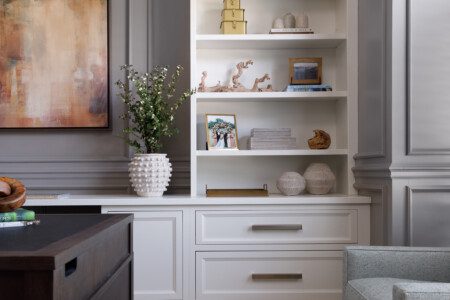 White bookshelf against grey walls with wall molding