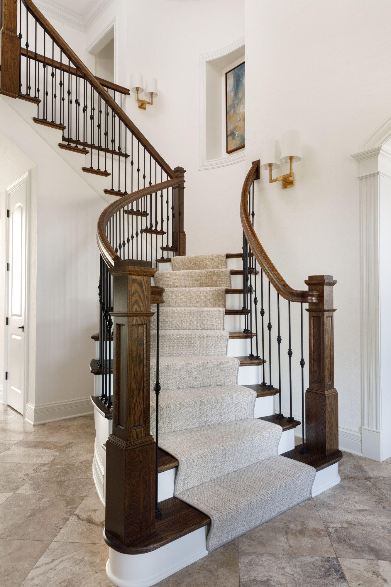 Open staircase with dark wood banisters, light carpet and walls