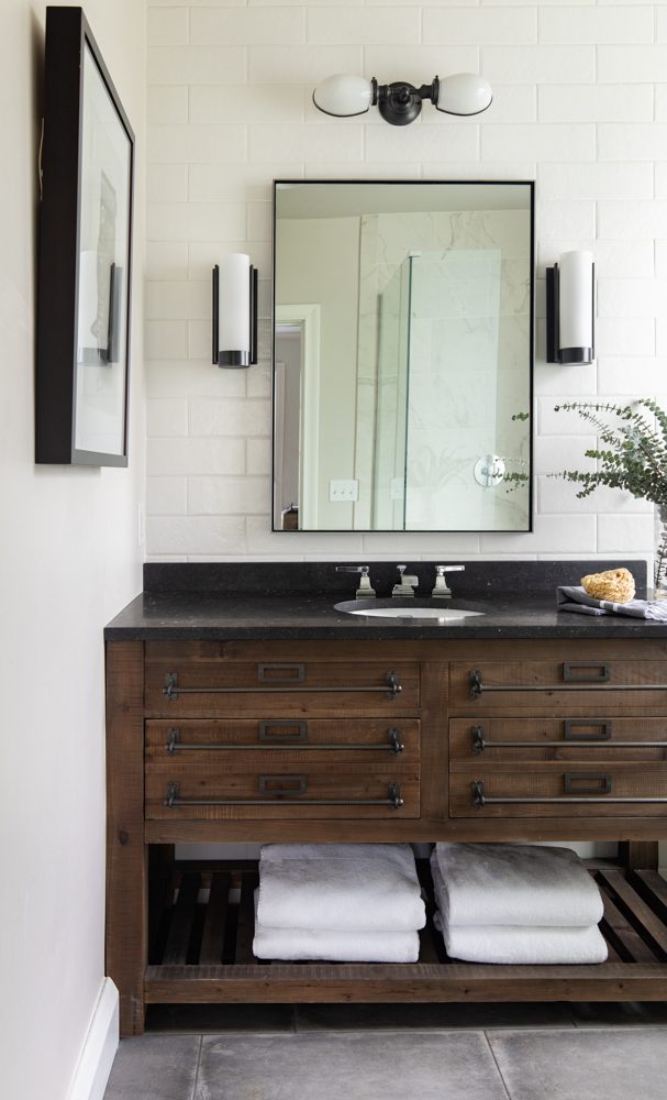 wooden vanity with white tile and black accents