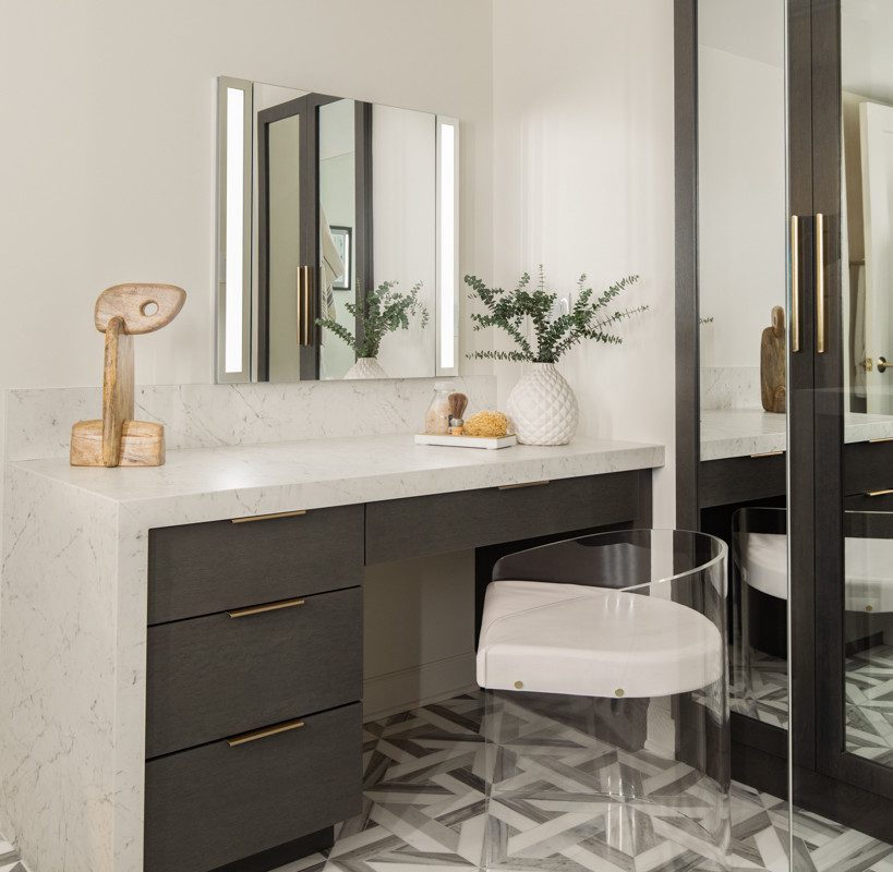 gorgeous makeup vanity with marble countertops and grey cabinetry