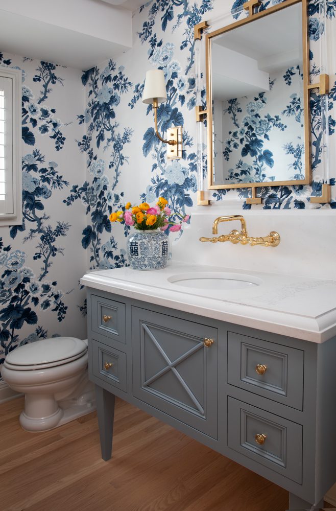 gorgeous bathroom with blue cabinetry and floral wallpaper