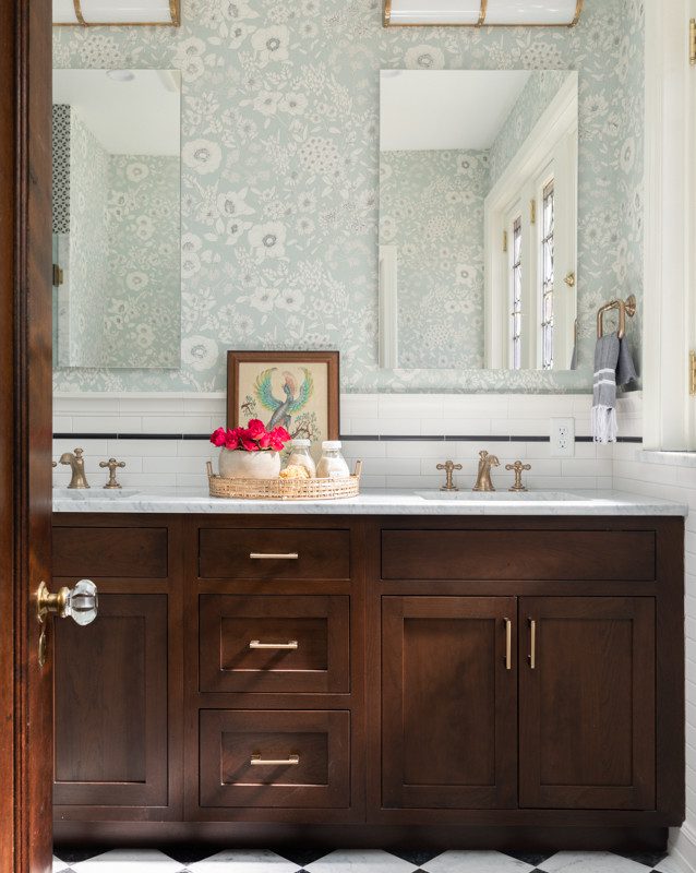 bright bathroom with floral wallpaper and brown cabinetry