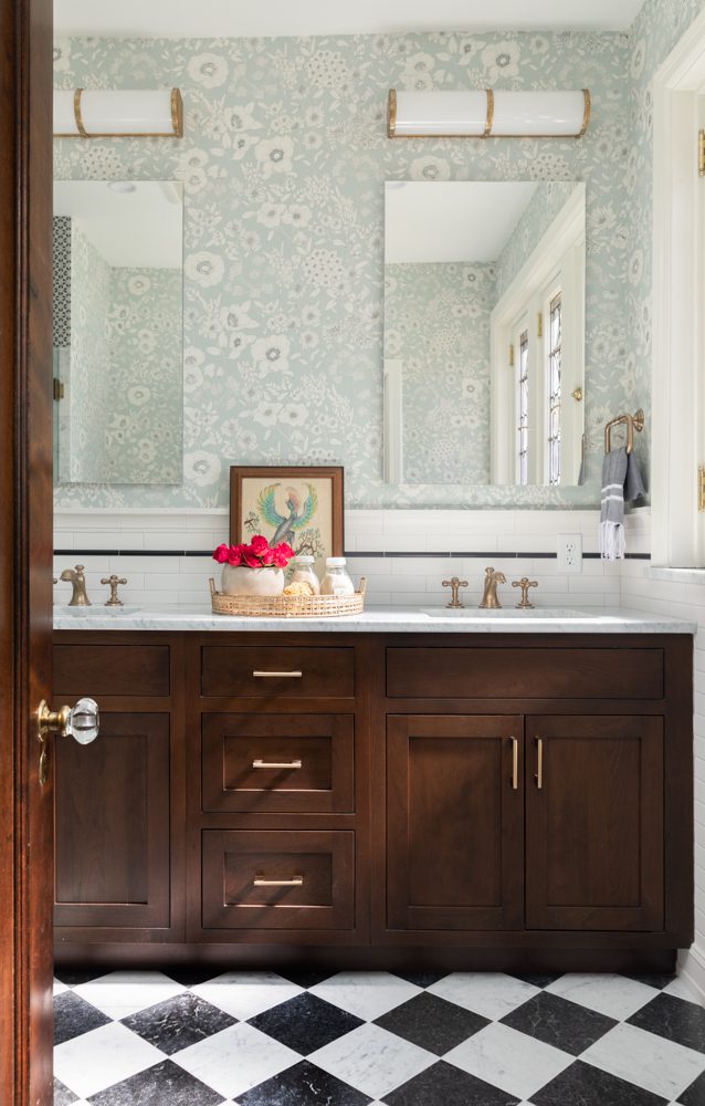 bright bathroom with floral wallpaper and brown cabinetry