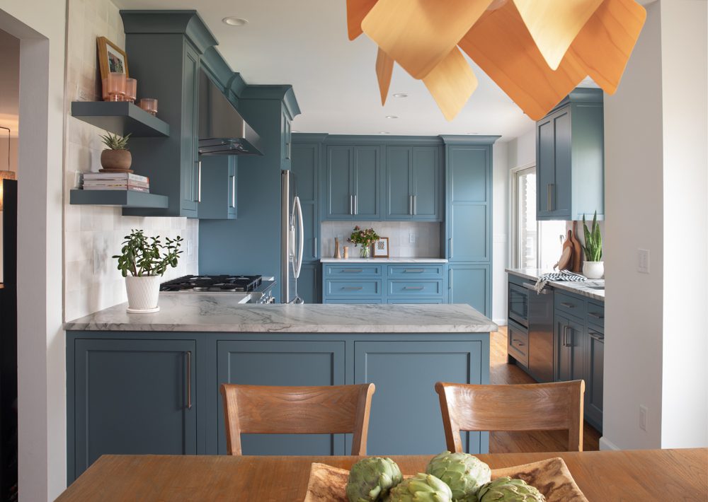 spacious kitchen with blue cabinetry and natural accents