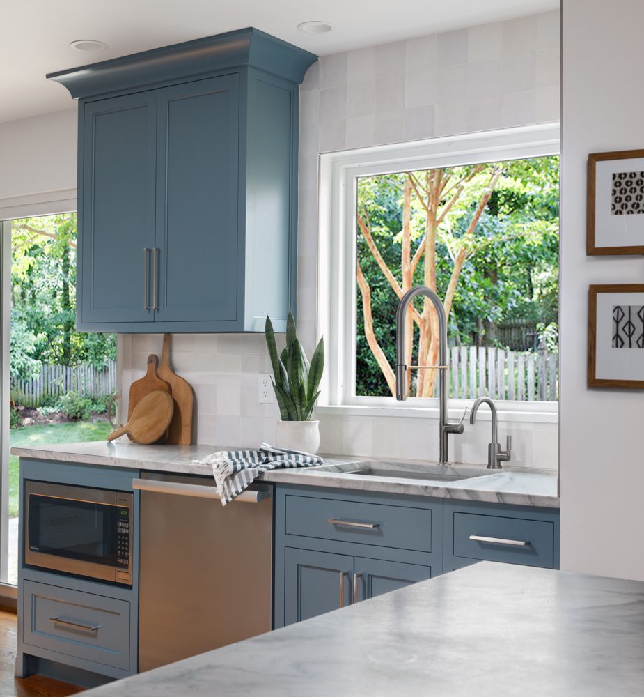 simplistic kitchen with blue cabinetry and a view of the backyard