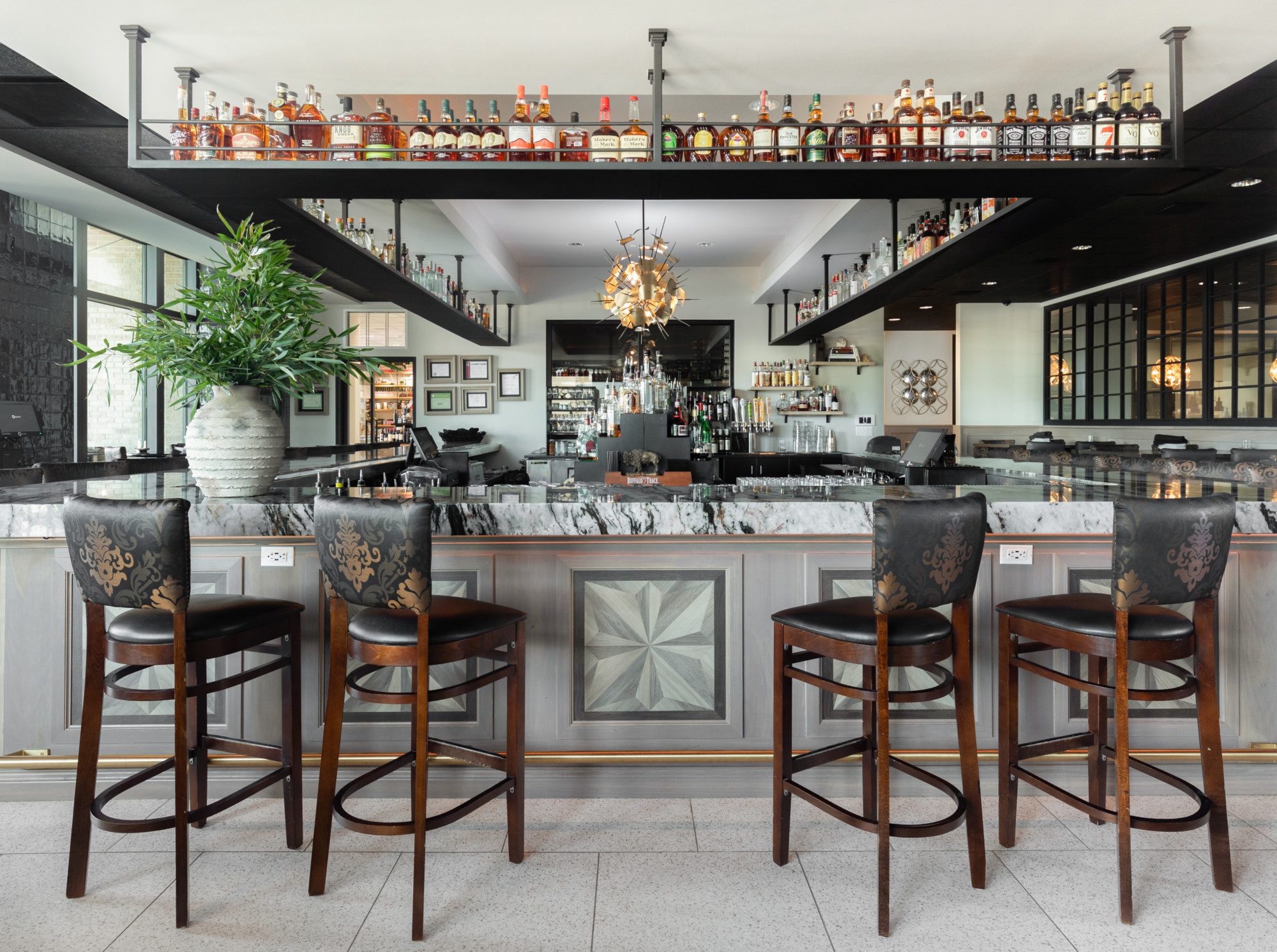 a restaurant bar with marble countertops and dark accents