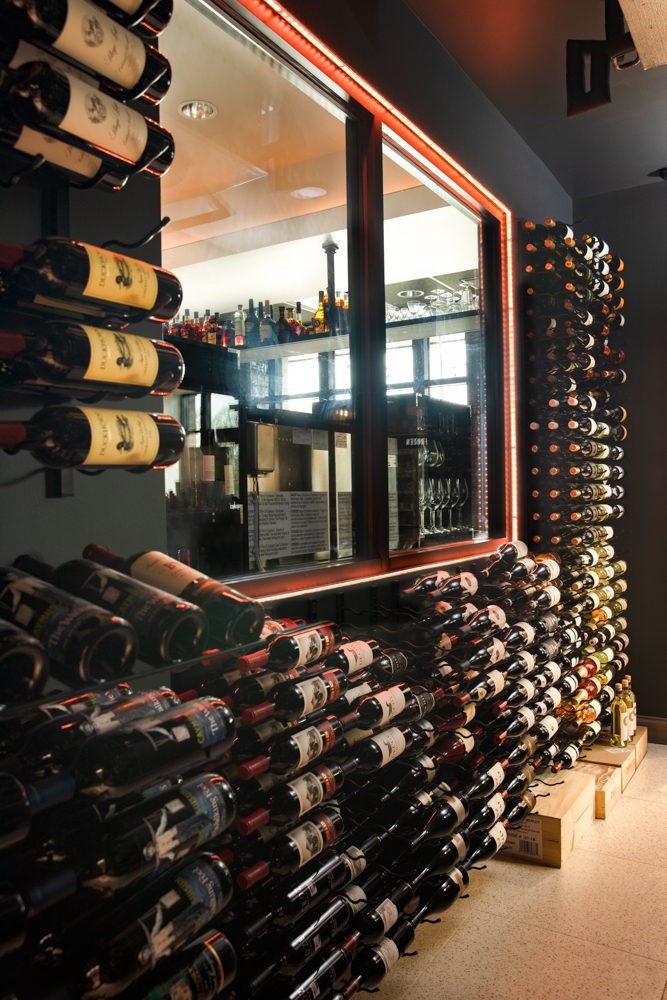 large wine rack against a black wall