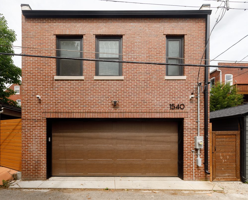 brick home with a wooden garage door and black trim