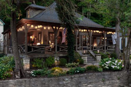 large screened in front porch with wooden and stone elements
