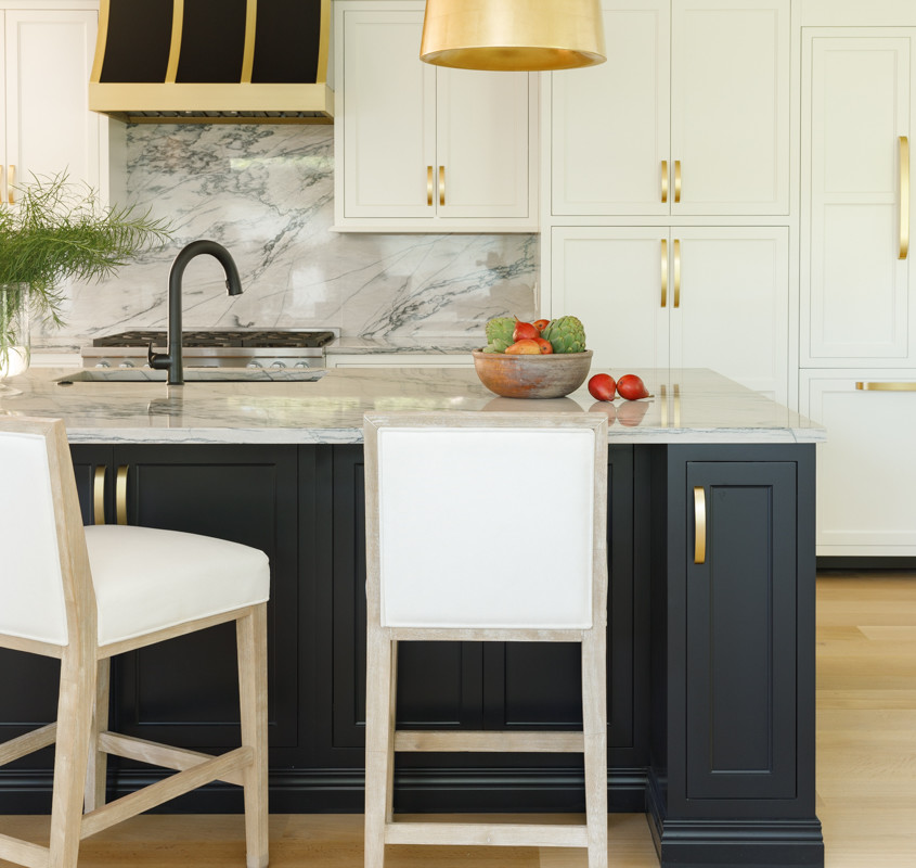 a modern kitchen with marble countertops and gold accents