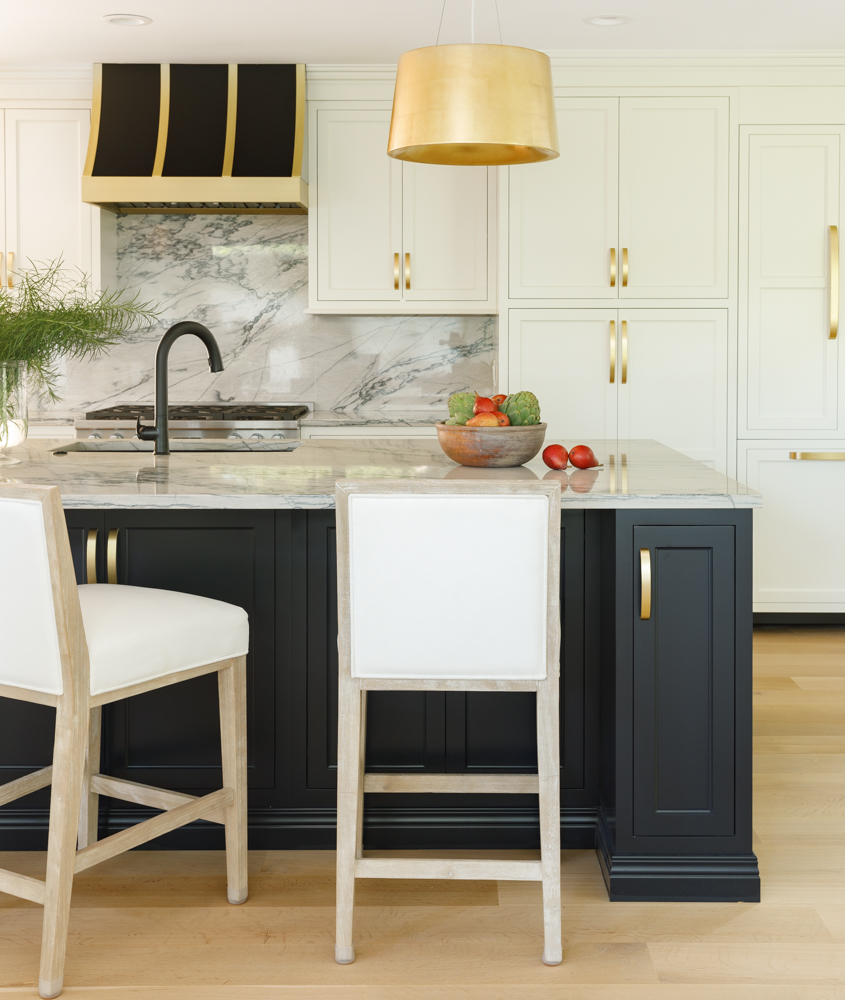 a modern kitchen with marble countertops and gold accents