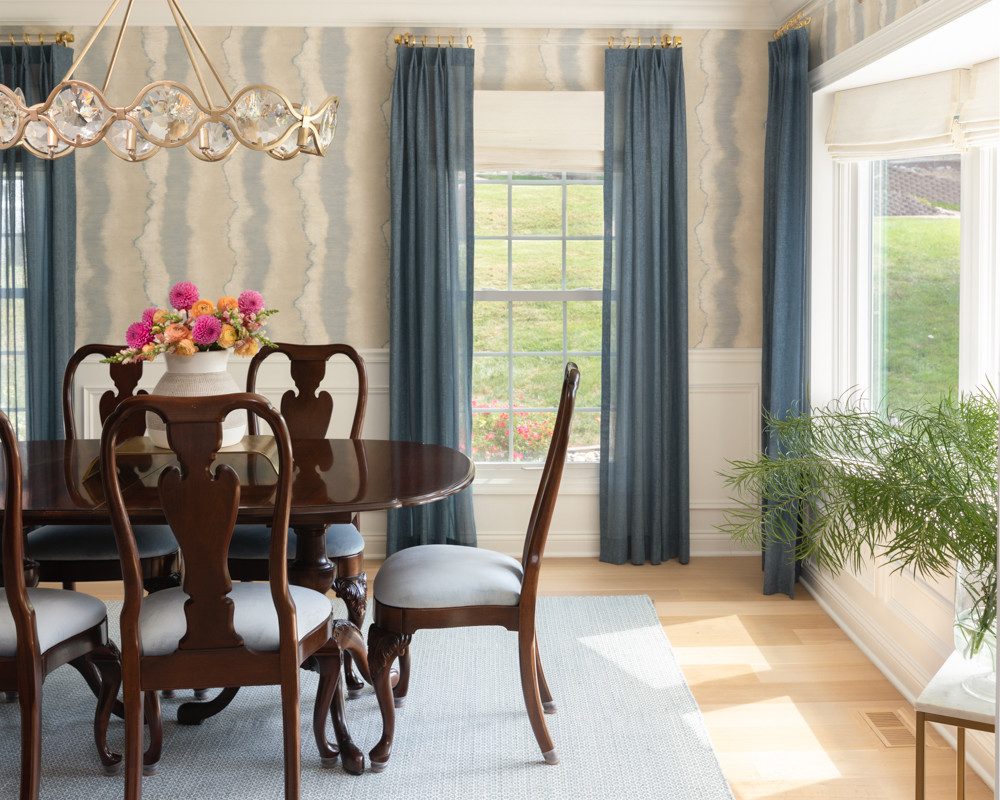 a simple dining room with natural light and striped wallpaper
