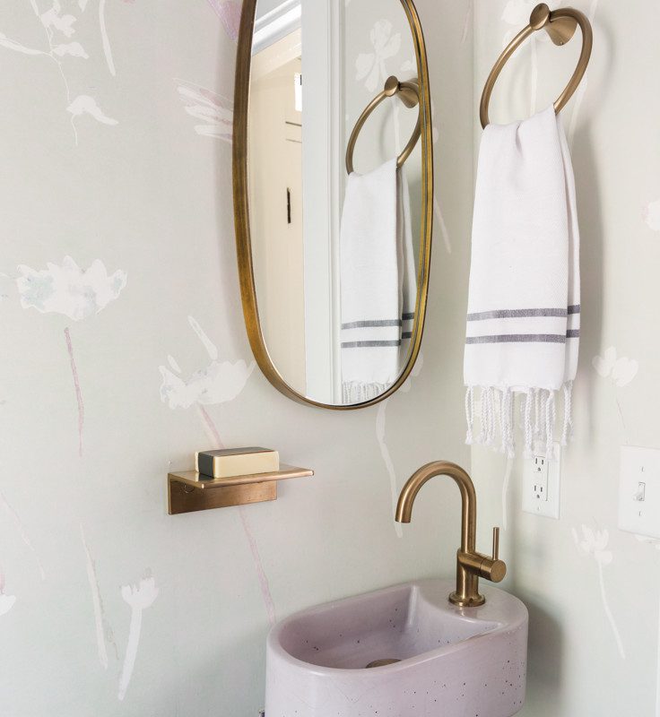 a small bathroom with gold accents