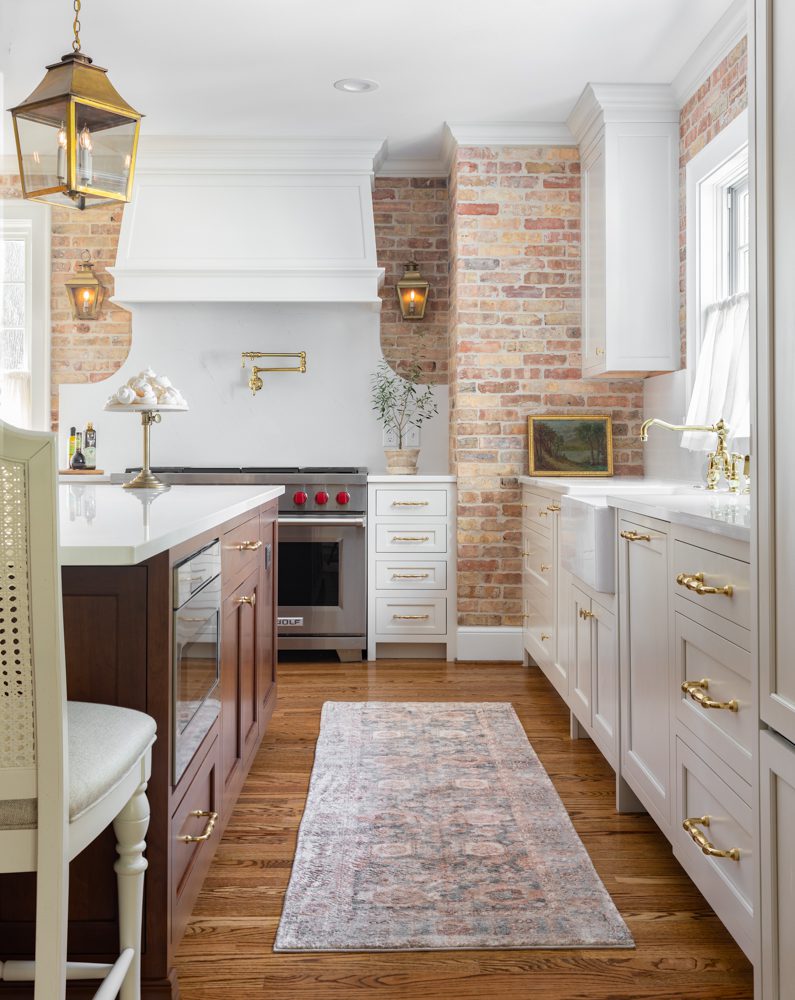 bright kitchen with brick walls and white cabinetry