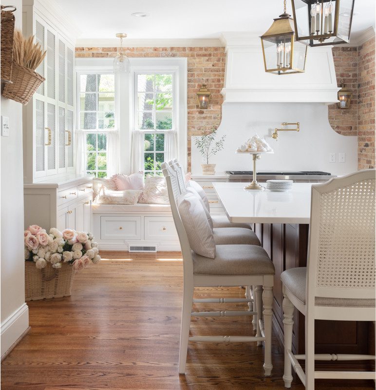 a spacious kitchen with brick walls and white accents