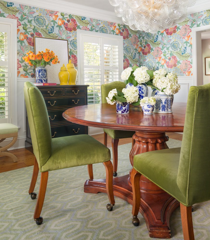 a gorgeous dining room with floral decor and green accents