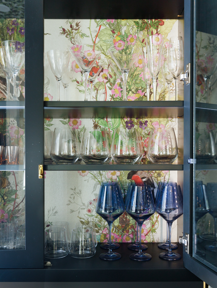 a china cabinet against floral wallpaper