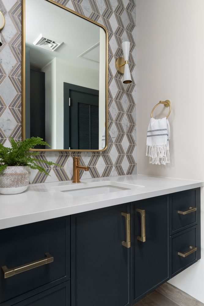 vanity with dark cabinetry and gold accents