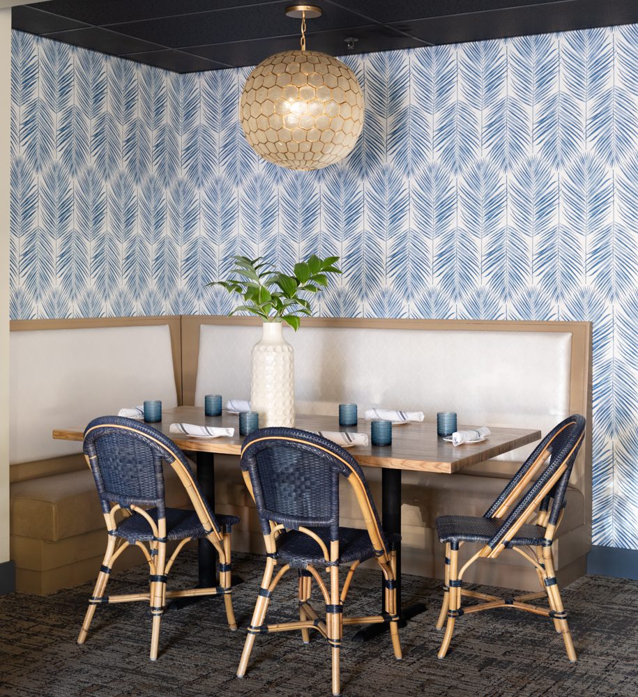 a coastal dining nook with blue wallpaper