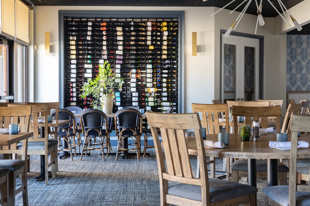 a restaurant with a large wine rack and natural elements