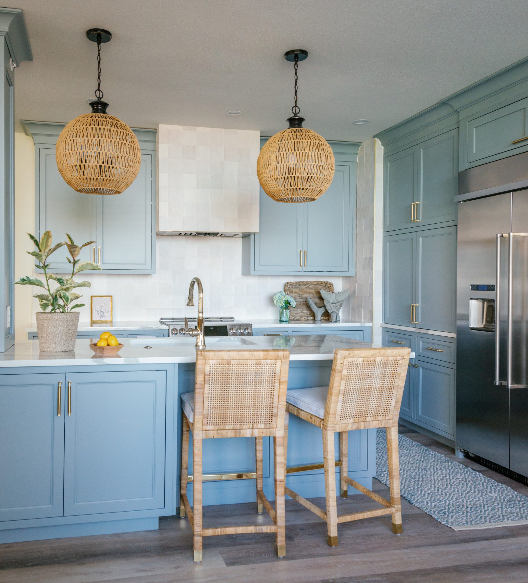 a spacious kitchen with blue cabinetry and natural accents