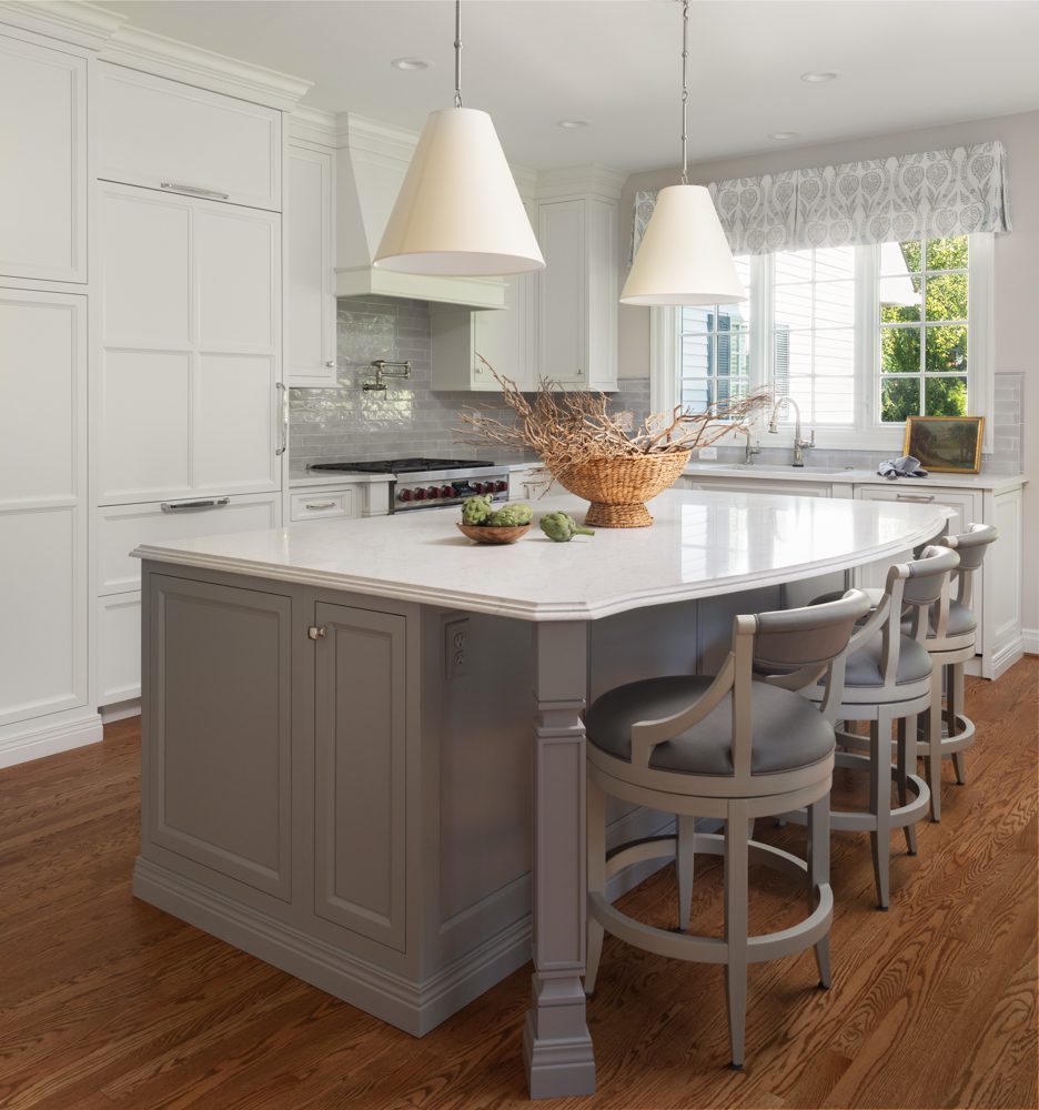 a light gray kitchen island with a white countertop in a beautifully designed kitchen